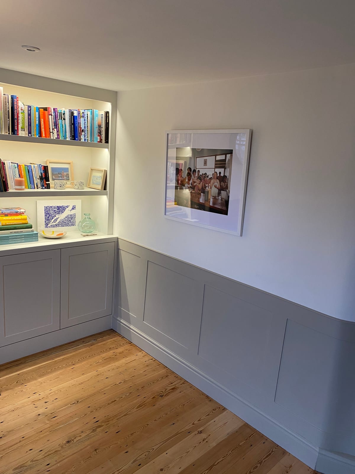 Fitted alcove bookshelf above panelled walls in a reading nook
