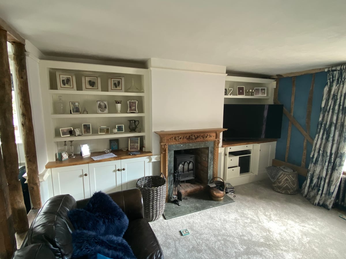 Fitted alcove shelving and cupboards either side of a period fireplace
