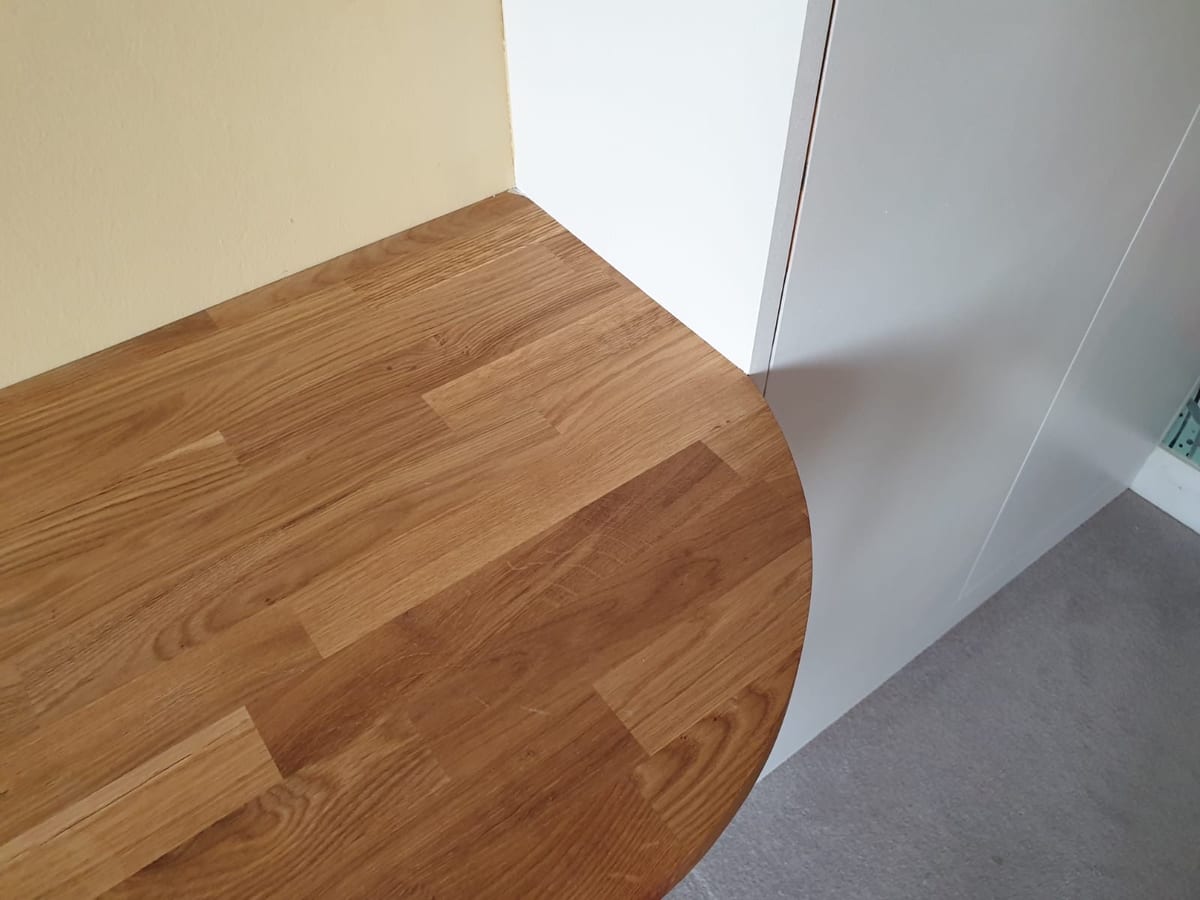 Curved solid oak surface with a rounded return, showing the joinery detail