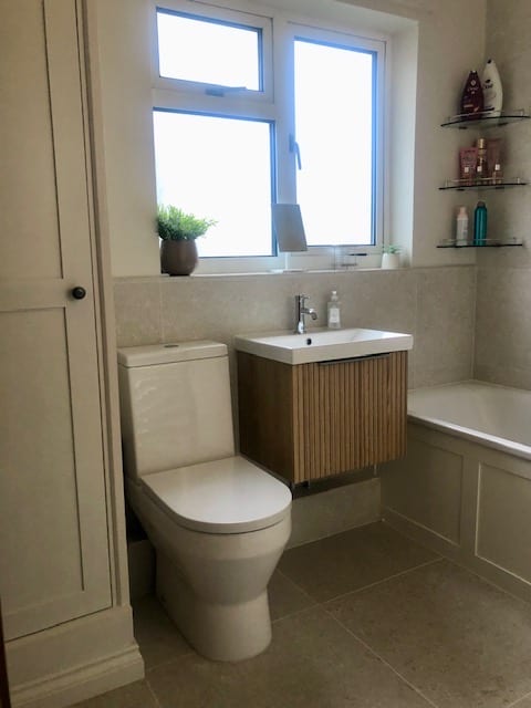 Family bathroom with an oak-fronted vanity unit, bath panel and airing cupboard