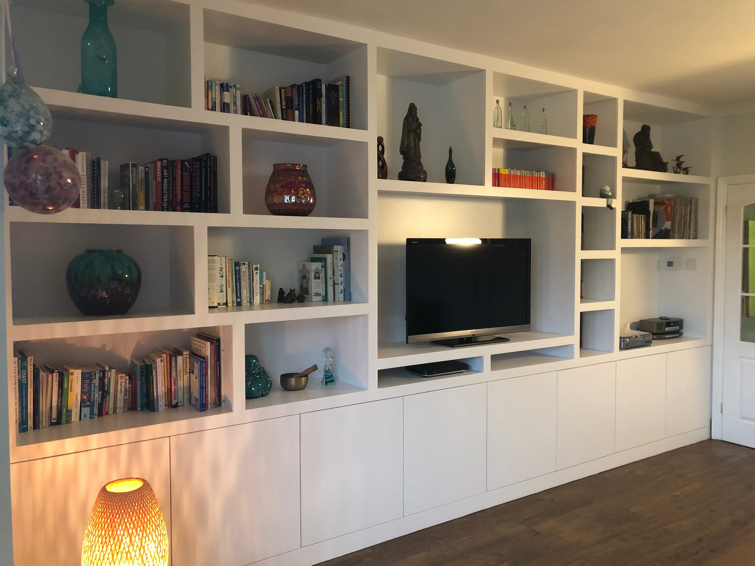 Bespoke fitted bookcase and media wall with display niches and cupboard storage