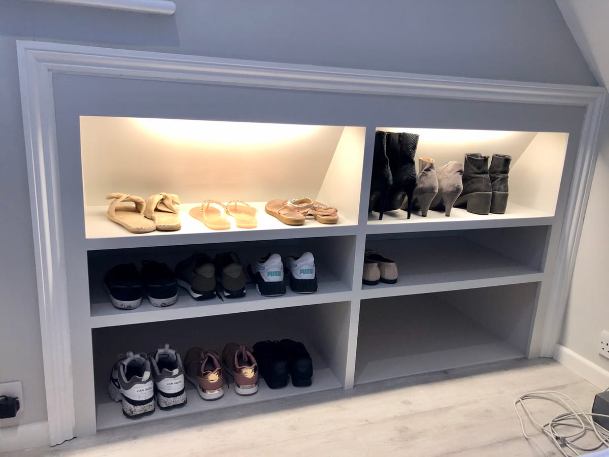 Built-in shoe storage nook with open shelving and integrated lighting