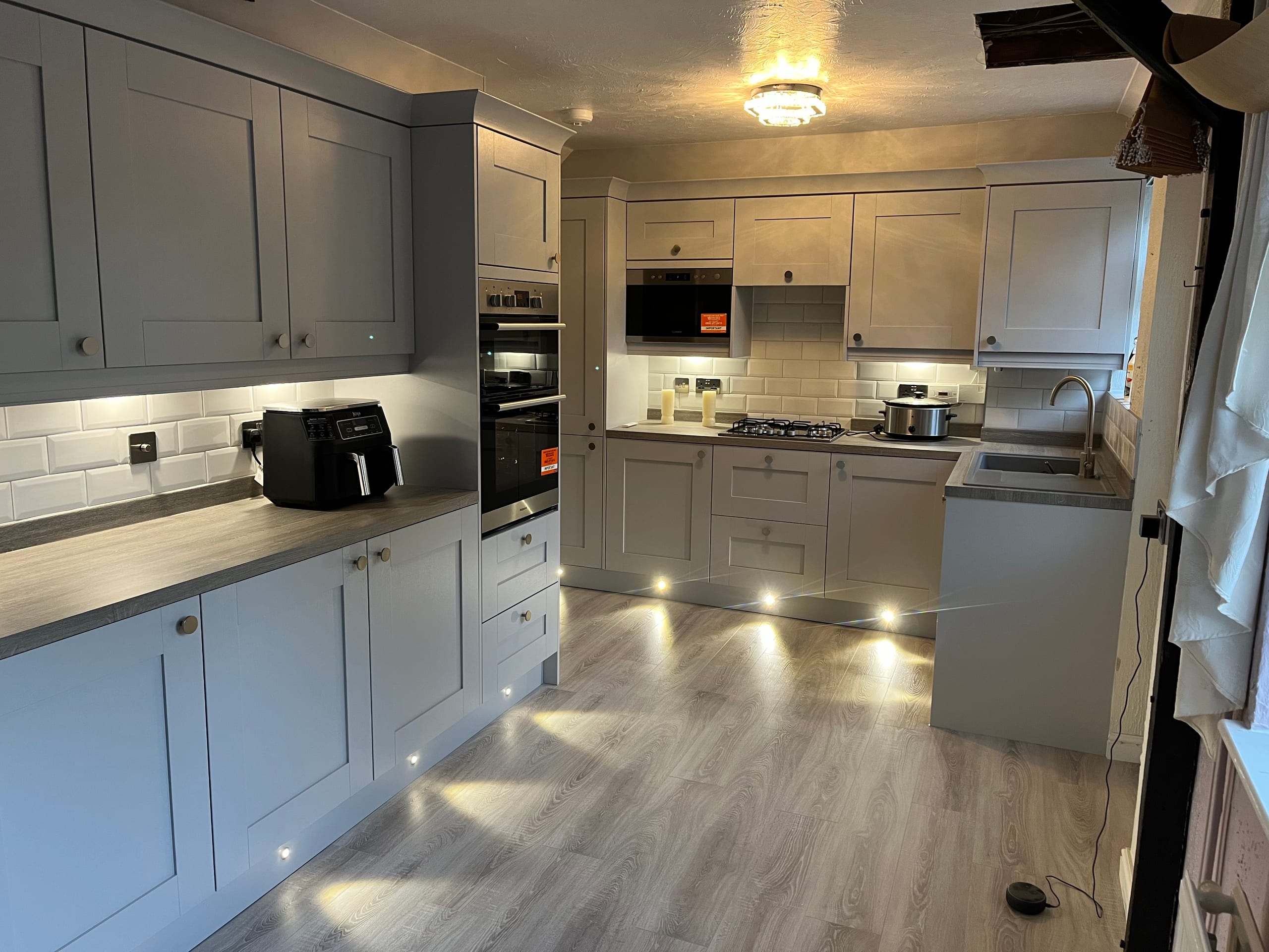 Grey shaker kitchen with integrated appliances and under-cabinet lighting
