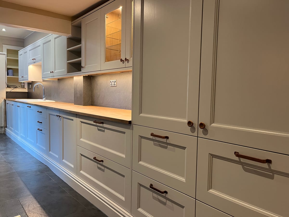 In-frame kitchen drawers and larder doors with cup handles and an oak worktop