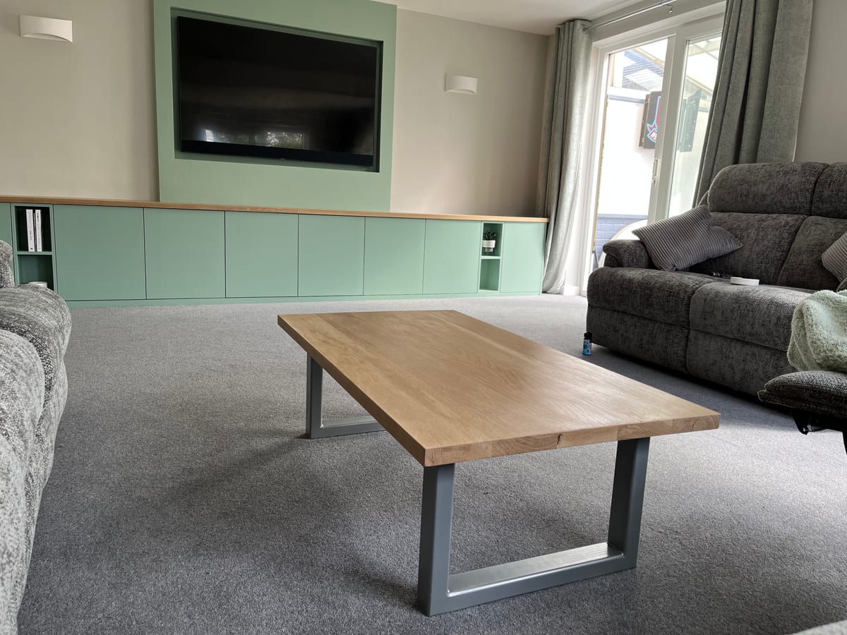 Fitted sideboard running beneath a wall-mounted TV with an oak coffee table