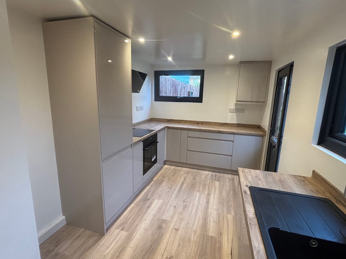 Modern open-plan kitchen in grey and charcoal with a wood-effect floor