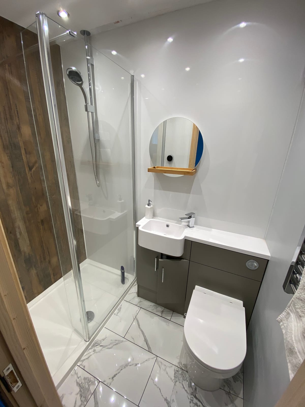Shower room with marble-effect tiling, a combined vanity and WC unit